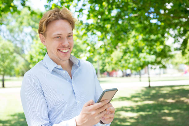 istock Joyful young entrepreneur using app on phone in park 1156862982