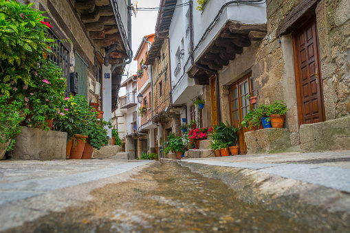 San Martin de Trevejo, Extremadura, Spain, April 2017: cobblestone street and houses of the village, including water canal