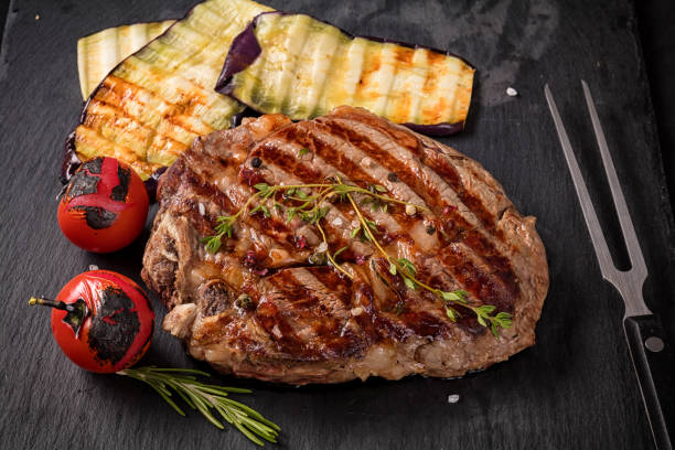 istock Juicy medium rare beef steak on black  ceramic board with herbs spices and salt. 1156864265