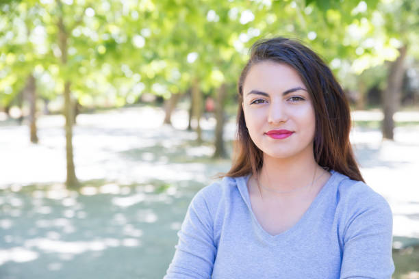 istock Content pretty young lady posing at camera in park 1156864333
