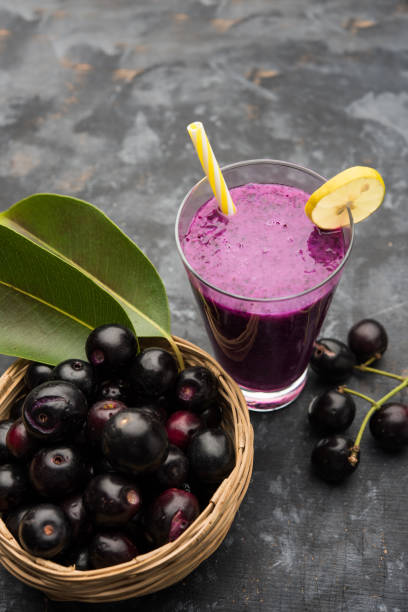 ジャワプラム、ジャンボランプラム、ジャンブル、シジジウムキュミニとも呼ばれるグラスのジャマンフルーツのジュース - plum fruit organic food and drink ストックフォトと画像