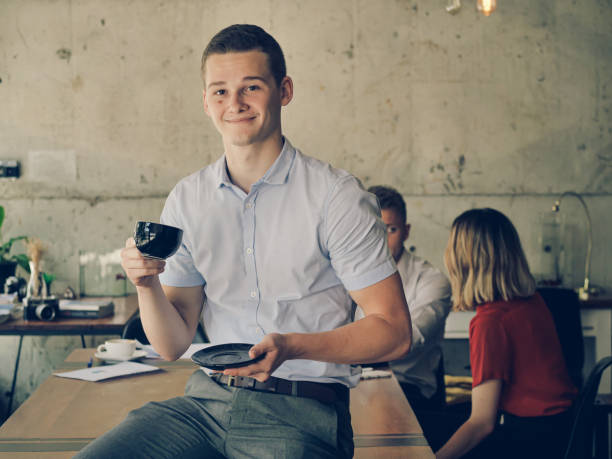 istock Successful young business man start up, drinking coffee and smiling in workplace 1156865814