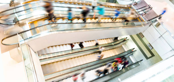 People in motion in escalators at the modern shopping mall.