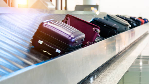 equipajes moviéndose en cinta transportadora aeroportuaria - purple belt fotografías e imágenes de stock