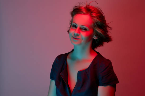 istock Beautiful attractive young woman posing in neon light in studio 1156867208