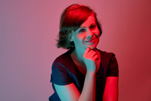 istock Beautiful attractive young woman posing in neon light in studio 1156867801