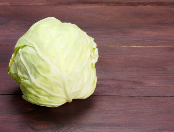 istock Green cabbage on a brown wooden background 1156868038