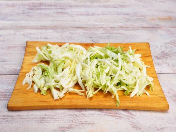 istock Chopped green cabbage on cutting board, wooden background with copy space 1156868345