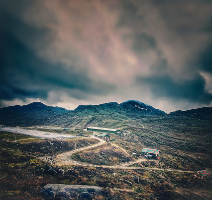 surreal landscape showing a stretch of road in mountains with blue clouds