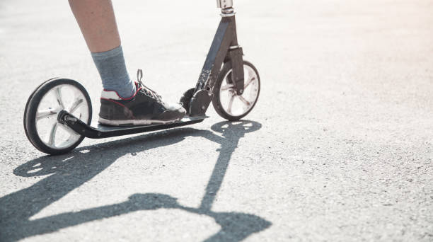 istock Boy on a scooter riding on the street. 1156871623