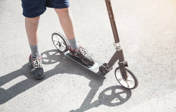 istock Boy on a scooter riding on the street. 1156871631