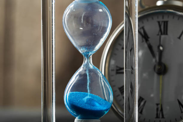 istock Time is passing. Blue hourglass close up 1156872370