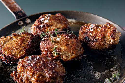 Pan fried  Danish meat balls or frikadeller in Danish. They are a staple of the Danish diet and they are traditionally made from a mix of veal and pork, herbs and spices such as sage and thyme as well as salt and pepper. Colour, horizontal with some copy space.