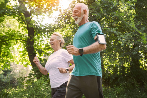 Smiling senior couple jogging in the park Smiling senior couple jogging pedometer photos stock pictures, royalty-free photos & images