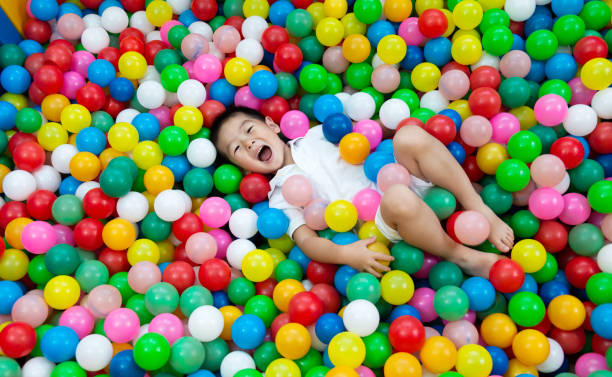 Four years old boy on the ball pool.
