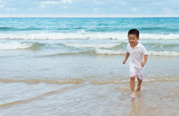 istock Asian boy have fun on the beach 1156875689