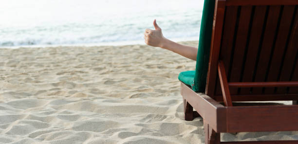 istock Man relaxing in a chair, enjoying the beach 1156876092