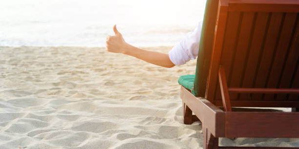 istock Man relaxing in a chair, enjoying the beach 1156876378