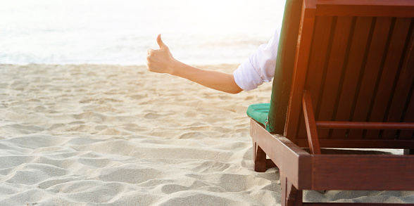 Man relaxing in a chair, enjoying the beach.