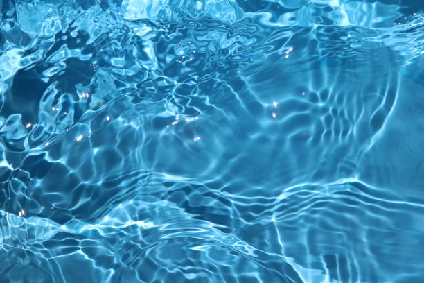 istock Blue and bright water surface with sun refection in swimming pool for background 1156877450