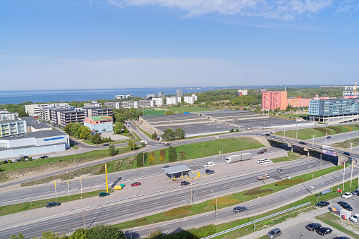 Tallinn, Estonia - September 7, 2018: Above view of Laagna highway in Tallinn Lasnamae district with residential high-rise buildings and \n view of part Gulf of Finland from house on Pae Pargi