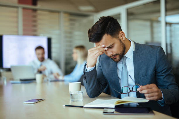 istock Young overworked businessman in the office 1156884133
