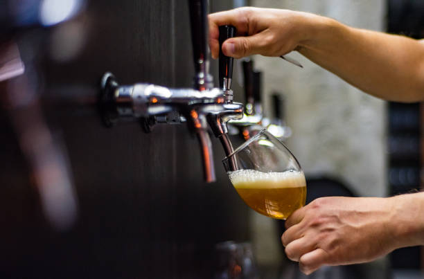 istock bartender hand at beer tap pouring a draught beer in glass serving in a restaurant or pub 1156884462
