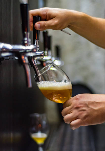 istock bartender hand at beer tap pouring a draught beer in glass serving in a restaurant or pub 1156884474