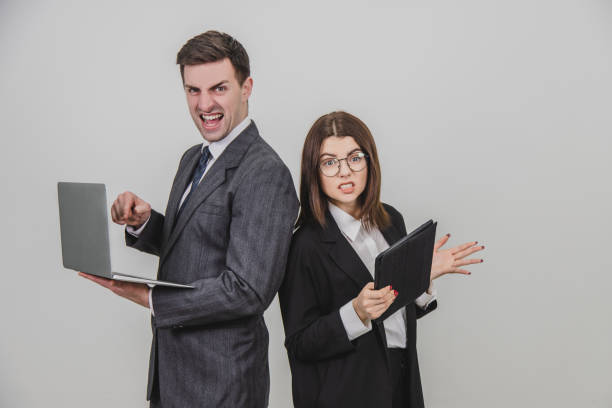 istock Busy successful work partners standing shoulder to shoulder, checking data. Man working with laptop, looking with irritated face expression, woman with tablet, setting her teeth. 1156885956