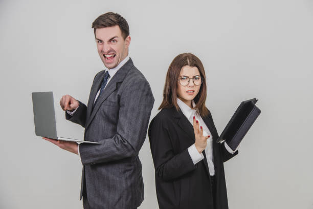 istock Busy successful work partners standing shoulder to shoulder, checking data. Man working with laptop, looking with irritated face expression, woman with tablet, woman asking for silence . 1156885964