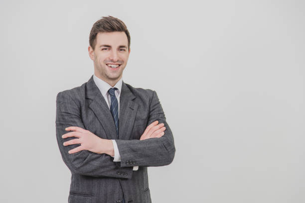 istock Smiling handsome businessman standing with his hands folded, looking confidently at the camera. 1156885990