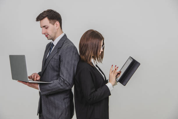 istock Busy successful work partners standing shoulder to shoulder, checking data. Man working with laptop, woman with tablet. 1156887485