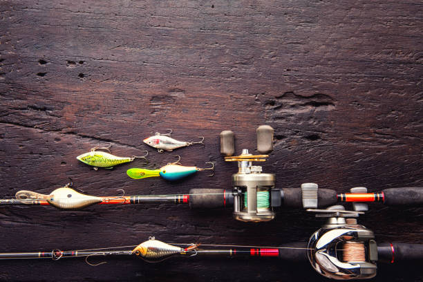 Fishing lures, hooks and accessories on darken wooden background.Top view stock photo
