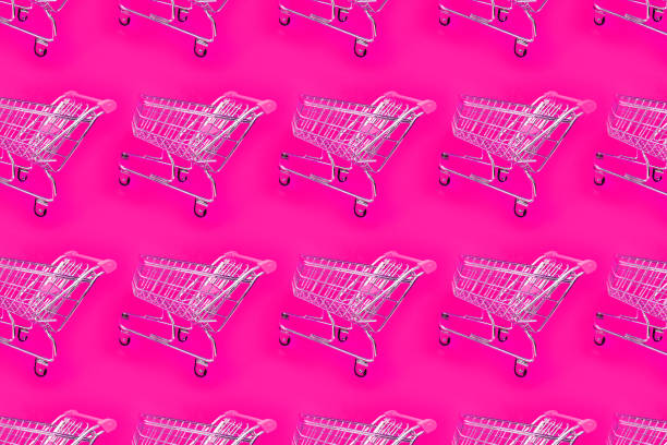 istock Bright pink background with a trolley for the supermarket. 1156891745