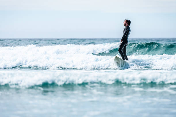 istock Surfer guy surfing with surfboard on waves in Atlantic ocean. 1156893104