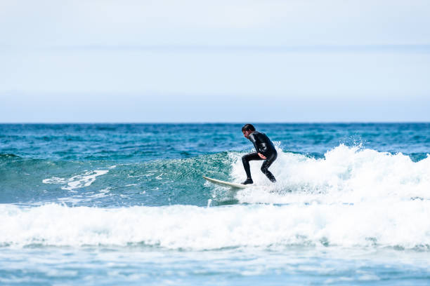 istock Surfer guy surfing with surfboard on waves in Atlantic ocean. 1156893117