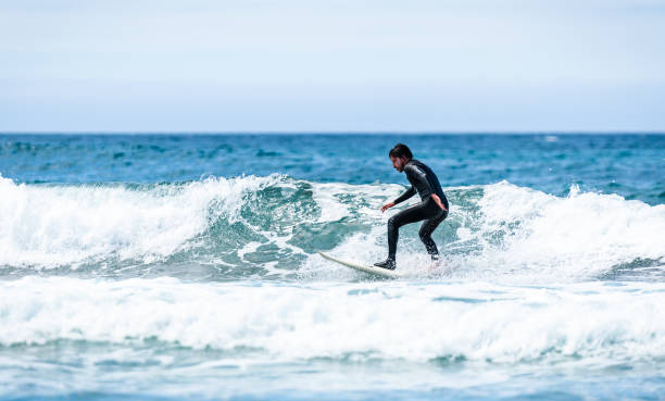 istock Surfer guy surfing with surfboard on waves in Atlantic ocean. 1156893151