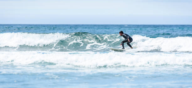 istock Surfer guy surfing with surfboard on waves in Atlantic ocean. 1156893177