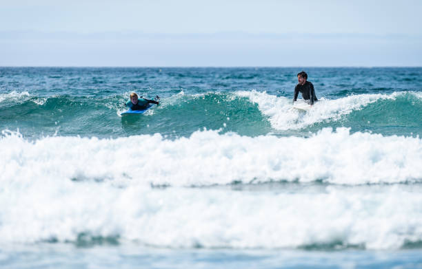 istock Young couple surfing with surfboard on waves in Atlantic ocean. 1156893938