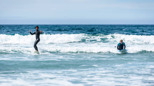 istock Young couple surfing with surfboard on waves in Atlantic ocean. 1156893944