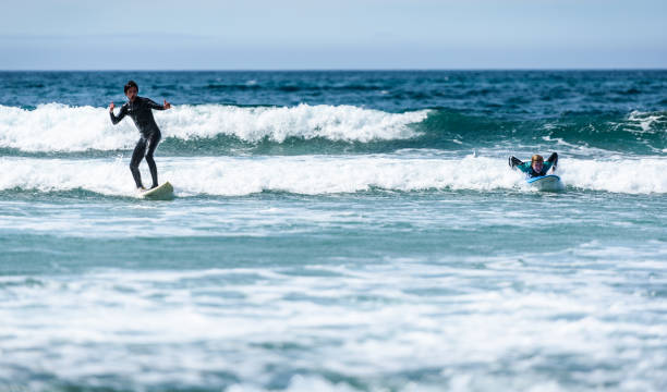 istock Young couple surfing with surfboard on waves in Atlantic ocean. 1156893957