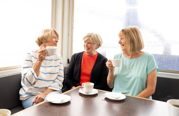 istock Joyful elderly friends having tea or coffee together. Senior girlfriends chatting laughing and having fun in coffee shop in Stay active in retirement lifestyle and friendship or companionship concept. 1156896251