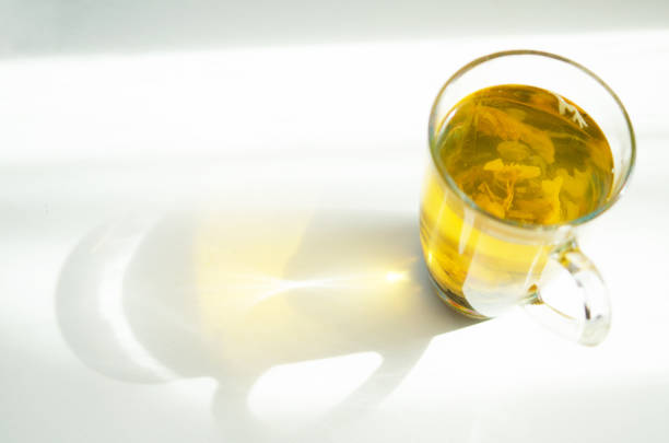 istock Brewed delicious herbal tea on a wooden white background, shadow and sun rays. - Image 1156898257