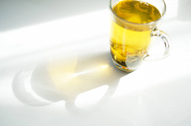 Brewed delicious herbal tea on a wooden white background, shadow and sun rays. - Image