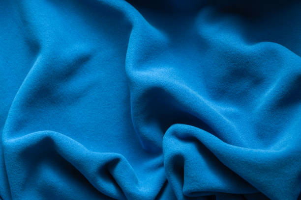 Background texture of blue fleece, soft napped insulating fabric made of polyester, wavy pattern, top view