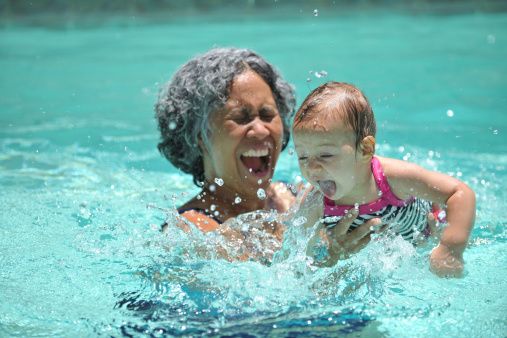 Baby and grandmother playing in the pool. - Buy credits