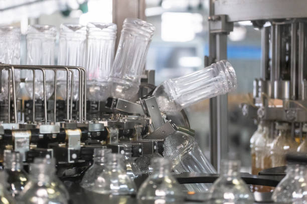 istock Plastic bottles inside industrial machine conveyor line or belt preparing for filling with drink. Water and juice bottling plant 1156902197
