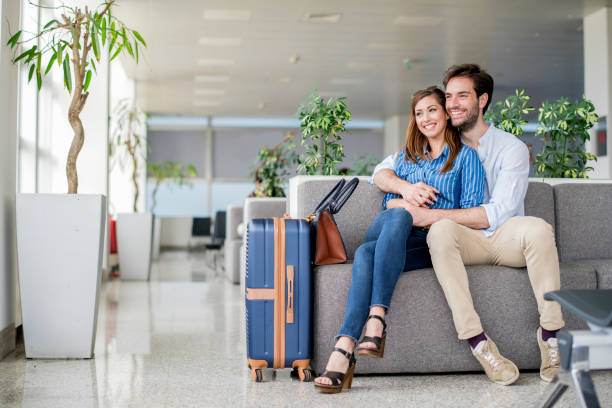 Tourist couple waiting for flight at airport lounge stock photo