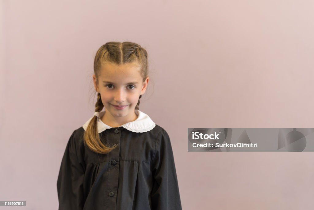 Elementary school student posing in uniform Pretty elementary school girl posing at camera 6-7 Years Stock Photo