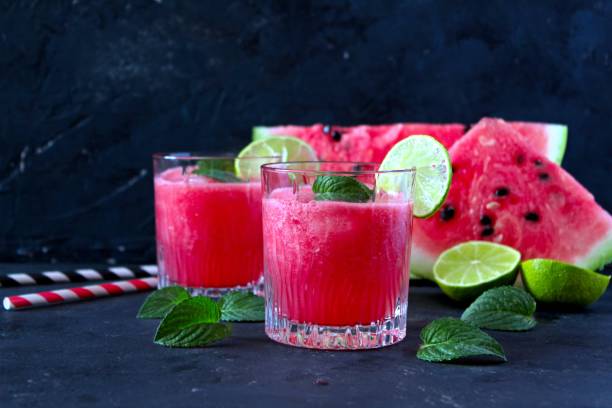istock Watermelon smoothie and slices with lime on dark background. 1156909108